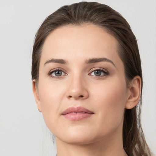 Joyful white young-adult female with long  brown hair and grey eyes