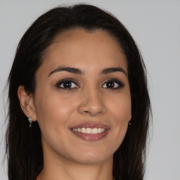 Joyful latino young-adult female with long  brown hair and brown eyes