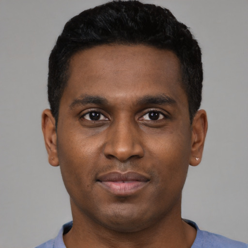 Joyful black young-adult male with short  black hair and brown eyes