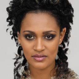 Joyful black young-adult female with long  black hair and brown eyes