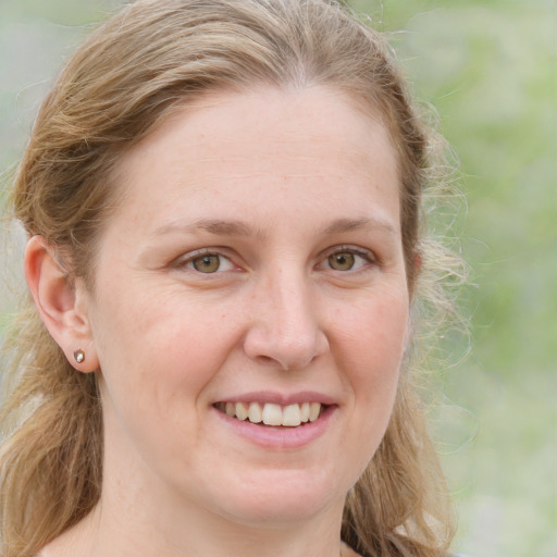 Joyful white young-adult female with long  brown hair and blue eyes