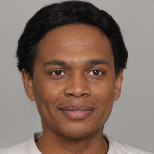 Joyful black young-adult male with short  black hair and brown eyes