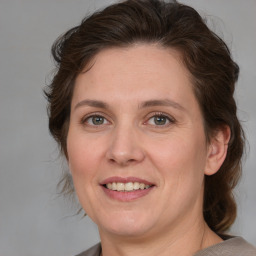 Joyful white adult female with medium  brown hair and grey eyes