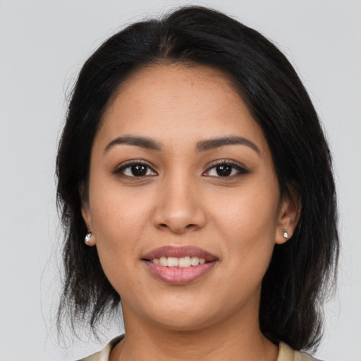 Joyful latino young-adult female with medium  brown hair and brown eyes