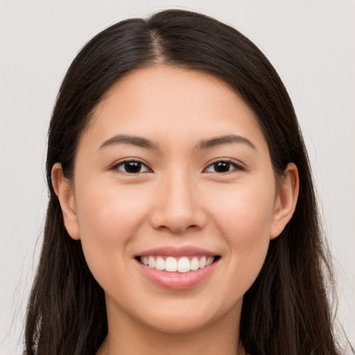 Joyful white young-adult female with long  brown hair and brown eyes