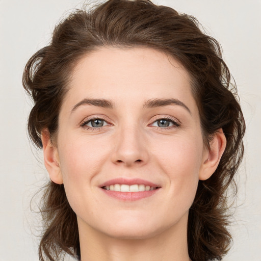 Joyful white young-adult female with medium  brown hair and green eyes