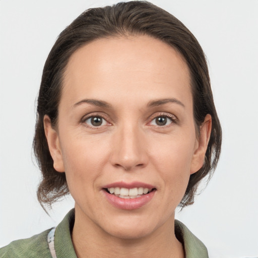 Joyful white adult female with medium  brown hair and grey eyes