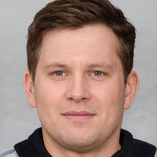 Joyful white adult male with short  brown hair and grey eyes