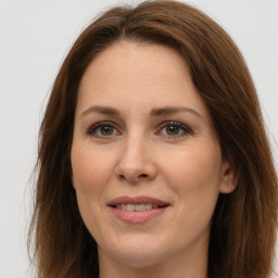 Joyful white adult female with long  brown hair and brown eyes