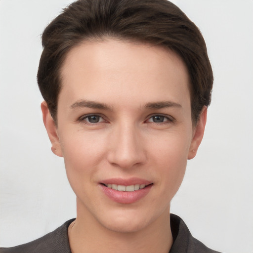 Joyful white young-adult female with short  brown hair and grey eyes