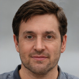 Joyful white adult male with short  brown hair and grey eyes