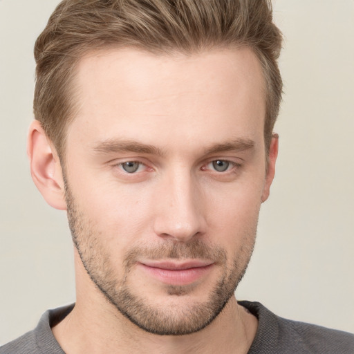 Joyful white young-adult male with short  brown hair and grey eyes