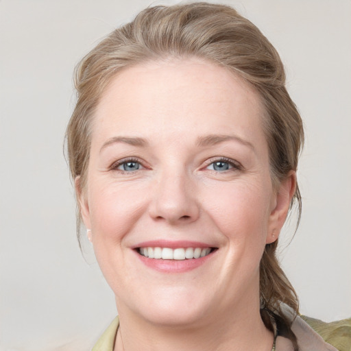 Joyful white young-adult female with medium  brown hair and blue eyes