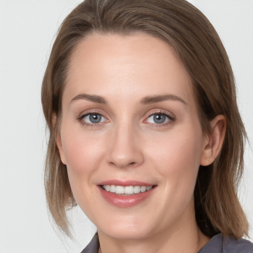 Joyful white young-adult female with medium  brown hair and grey eyes