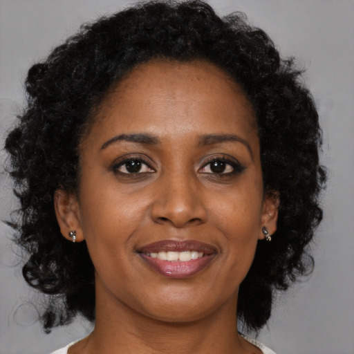 Joyful black young-adult female with medium  brown hair and brown eyes