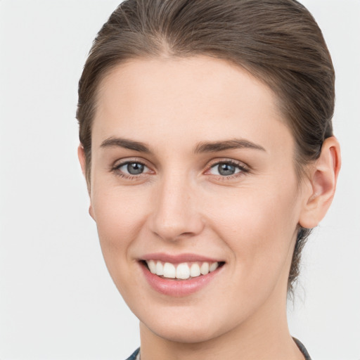 Joyful white young-adult female with medium  brown hair and grey eyes