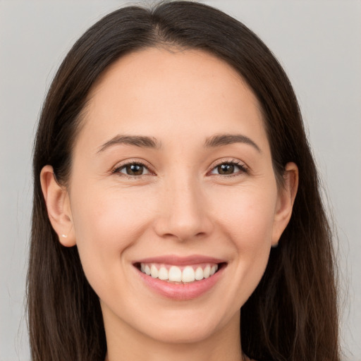 Joyful white young-adult female with long  brown hair and brown eyes