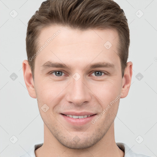 Joyful white young-adult male with short  brown hair and grey eyes