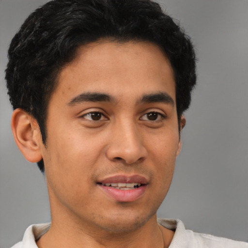 Joyful latino young-adult male with short  brown hair and brown eyes