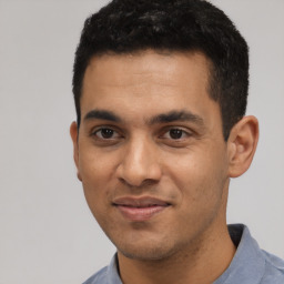 Joyful latino young-adult male with short  black hair and brown eyes