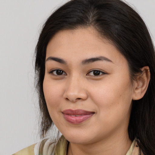 Joyful latino young-adult female with long  brown hair and brown eyes