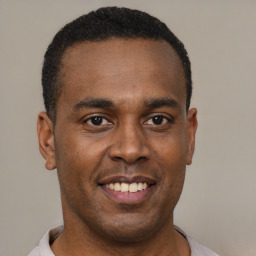 Joyful latino young-adult male with short  brown hair and brown eyes