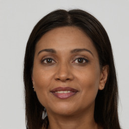 Joyful black adult female with long  brown hair and brown eyes