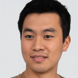 Joyful asian young-adult male with short  black hair and brown eyes