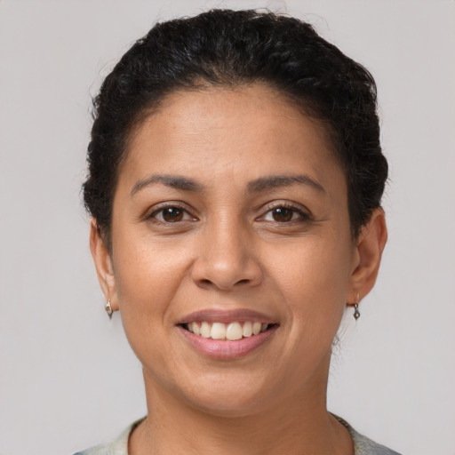 Joyful latino young-adult female with short  brown hair and brown eyes