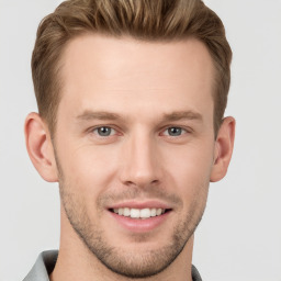 Joyful white young-adult male with short  brown hair and grey eyes