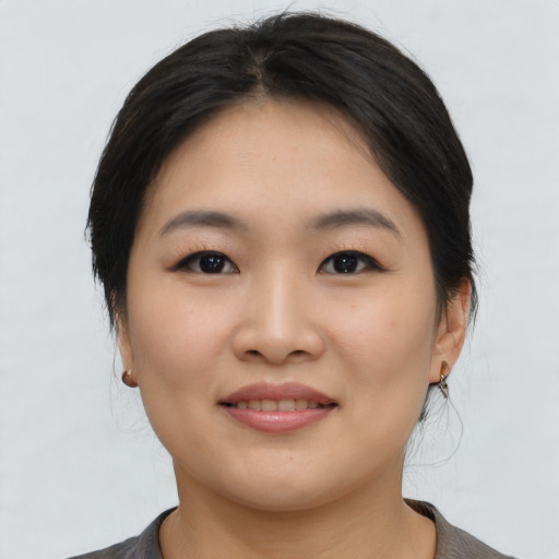 Joyful asian young-adult female with medium  brown hair and brown eyes