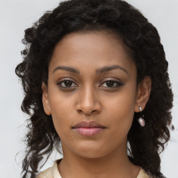 Joyful black young-adult female with long  brown hair and brown eyes