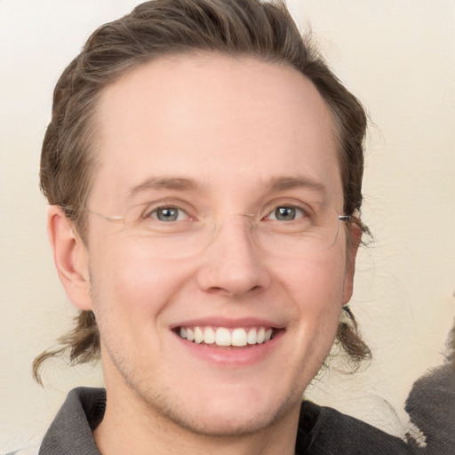 Joyful white young-adult male with medium  brown hair and grey eyes