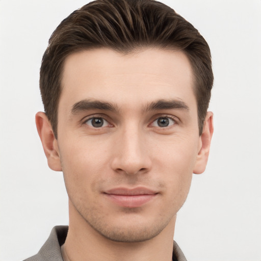 Joyful white young-adult male with short  brown hair and grey eyes