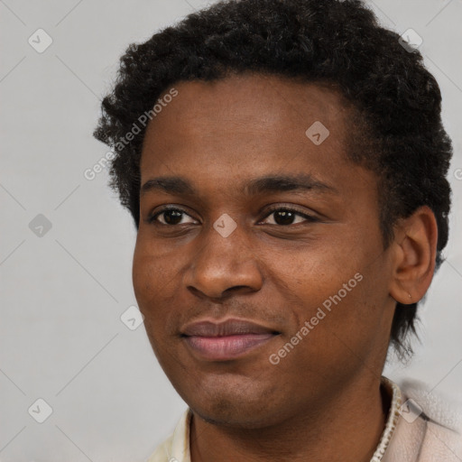 Joyful black young-adult male with short  brown hair and brown eyes