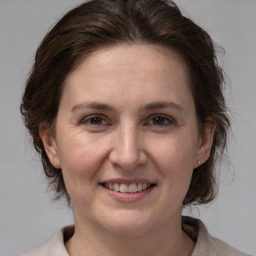 Joyful white adult female with medium  brown hair and brown eyes