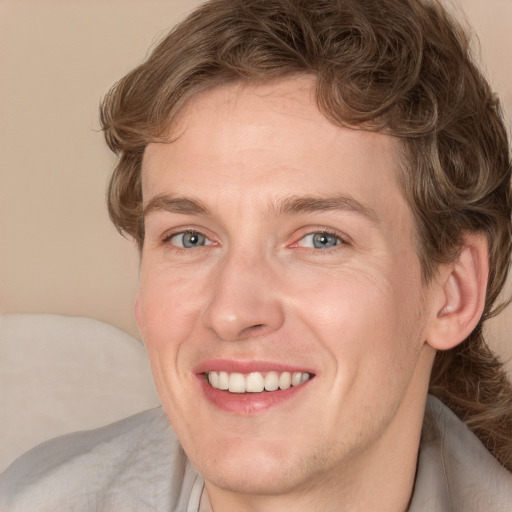 Joyful white adult male with medium  brown hair and blue eyes