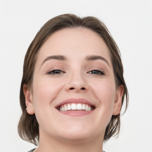 Joyful white young-adult female with medium  brown hair and grey eyes