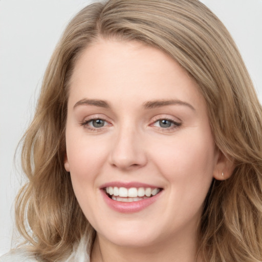 Joyful white young-adult female with long  brown hair and blue eyes