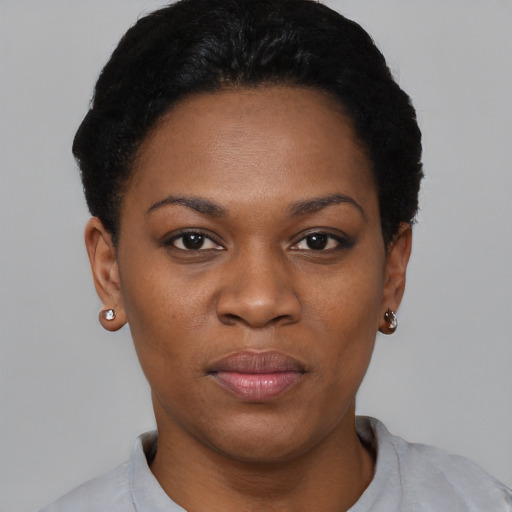 Joyful black young-adult female with short  black hair and brown eyes