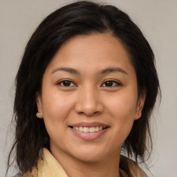 Joyful latino young-adult female with medium  brown hair and brown eyes