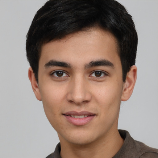 Joyful white young-adult male with short  black hair and brown eyes