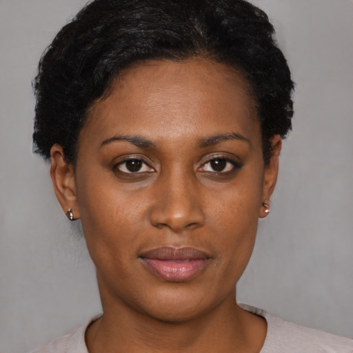 Joyful black young-adult female with short  black hair and brown eyes