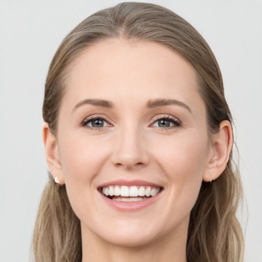 Joyful white young-adult female with long  brown hair and blue eyes