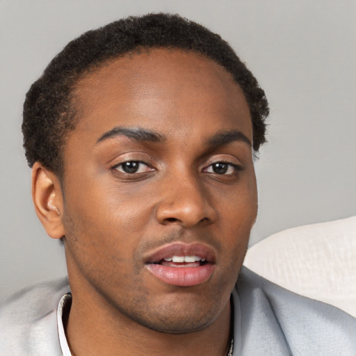 Joyful black young-adult male with short  brown hair and brown eyes