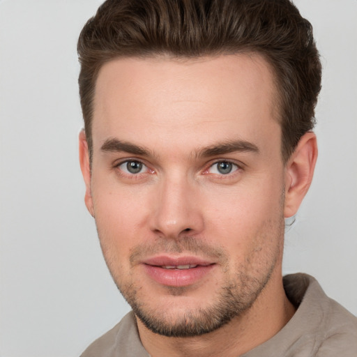 Joyful white young-adult male with short  brown hair and grey eyes