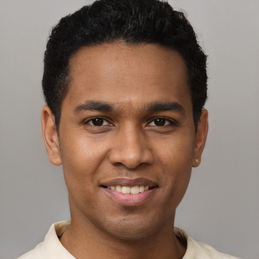 Joyful black young-adult male with short  black hair and brown eyes