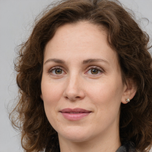 Joyful white adult female with medium  brown hair and green eyes