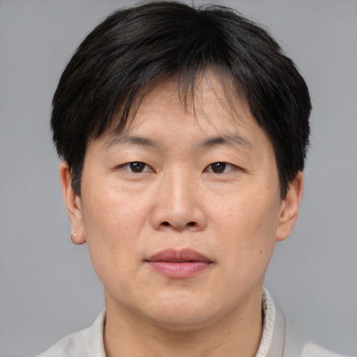 Joyful asian adult male with short  brown hair and brown eyes