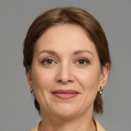 Joyful white adult female with medium  brown hair and grey eyes